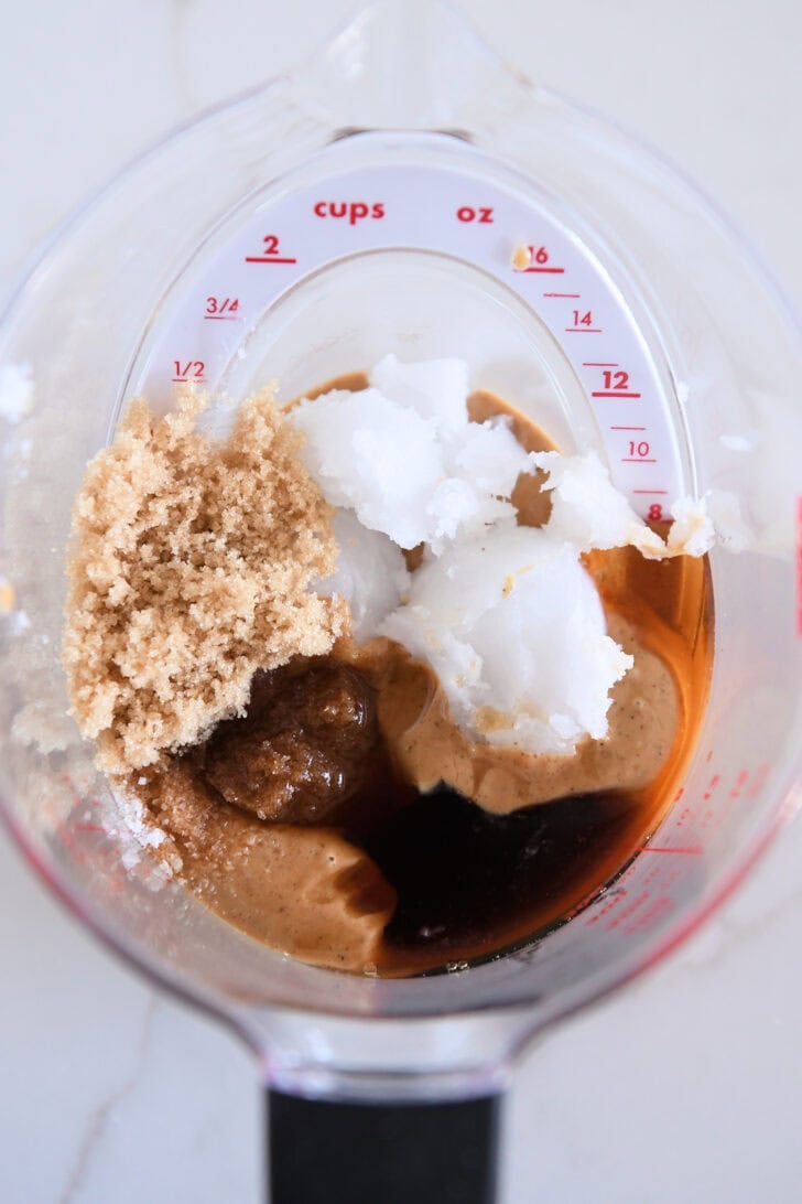 Liquid measuring cup with coconut oil, brown sugar, maple syrup, peanut butter and vanilla.