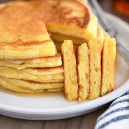 Four triangle slices cut out of stack of four pancakes on gray plate.