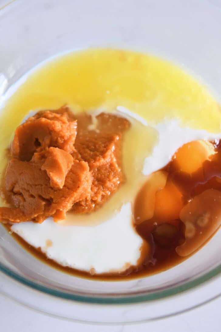 Glass bowl with canned pumpkin puree, eggs, buttermilk, butter and vanilla.