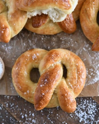 Top down view of baked and buttered soft homemade pretzel sprinkled with coarse salt.