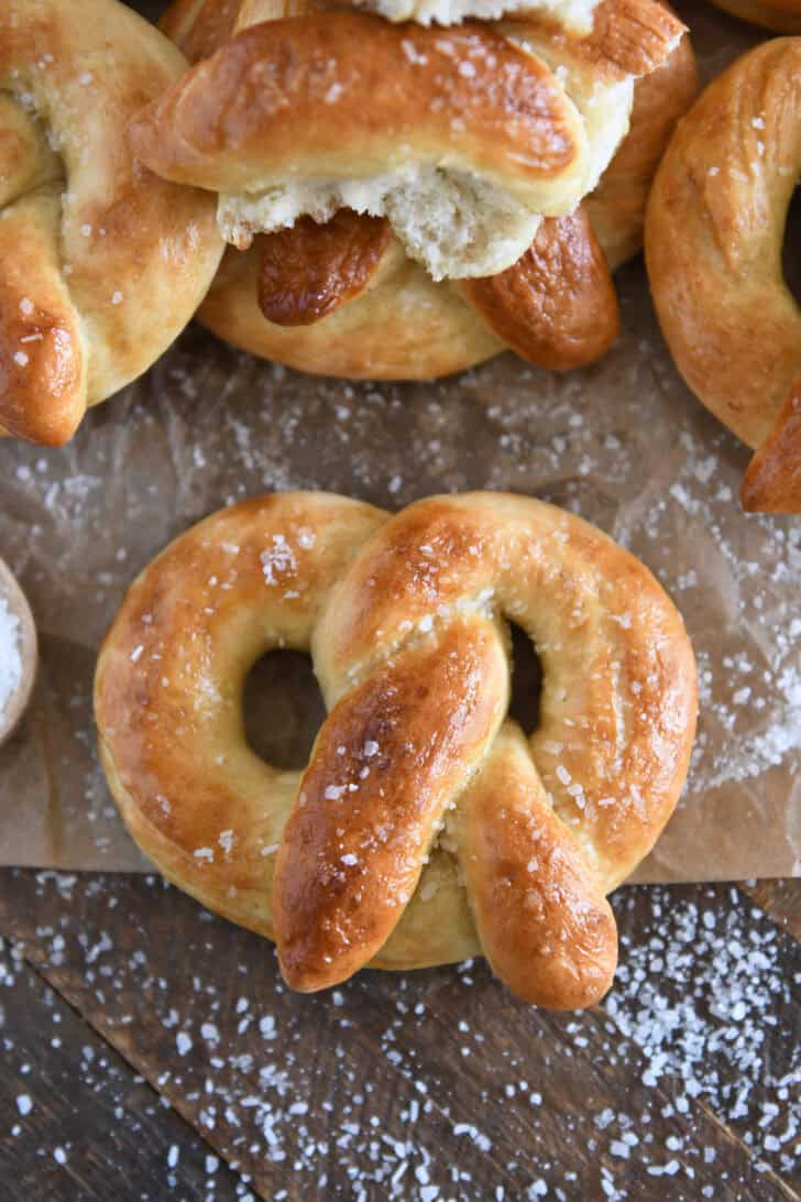 Top down view of baked and buttered soft homemade pretzel sprinkled with coarse salt.