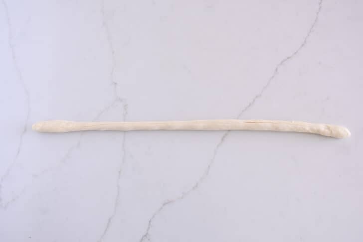 Piece of pretzel dough rolled into very long thin rope.