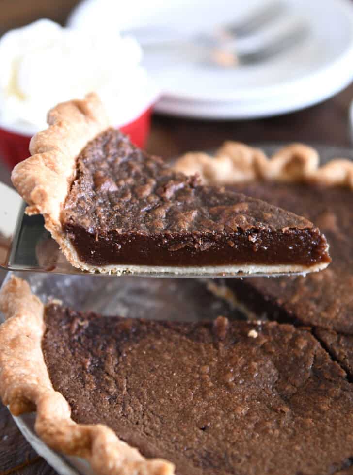Slice of chocolate chess pie on pie server.