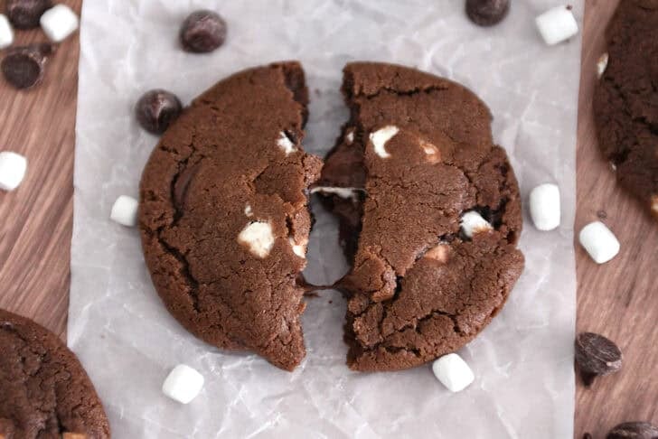 Chocolate cookie broken in half and spread apart with gooey melted chocolate chips and marshmallows.