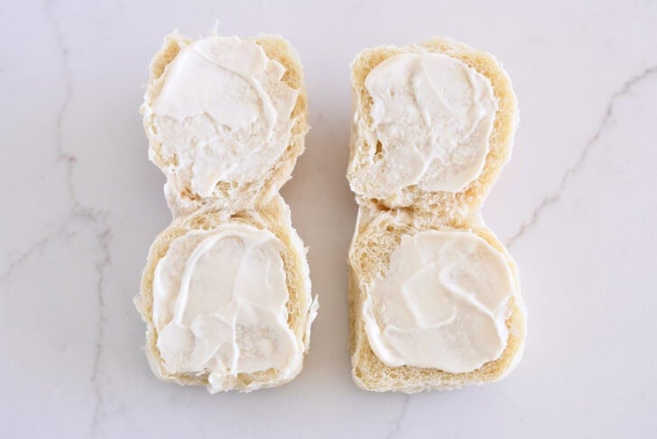 Two rolls opened and spread with mayonnaise on each side.