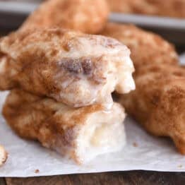 Two half cinnamon twists dipped in icing and stacked on each other.