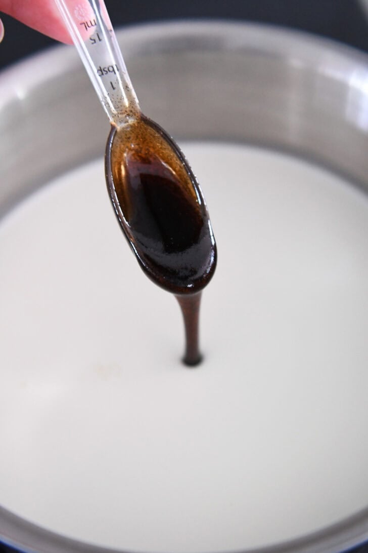 Tablespoon drizzling vanilla bean paste into pan with cream.