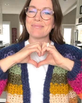 Mel holding up hand heart.