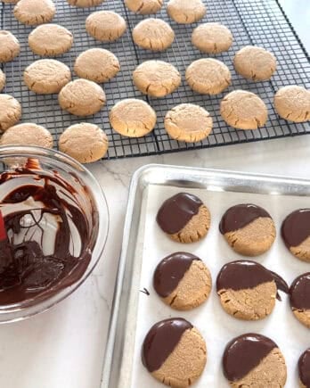 Peanut butter cookies on cooling rack with melted chocolate.