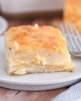 Square of baked au gratin potatoes on gray plate.