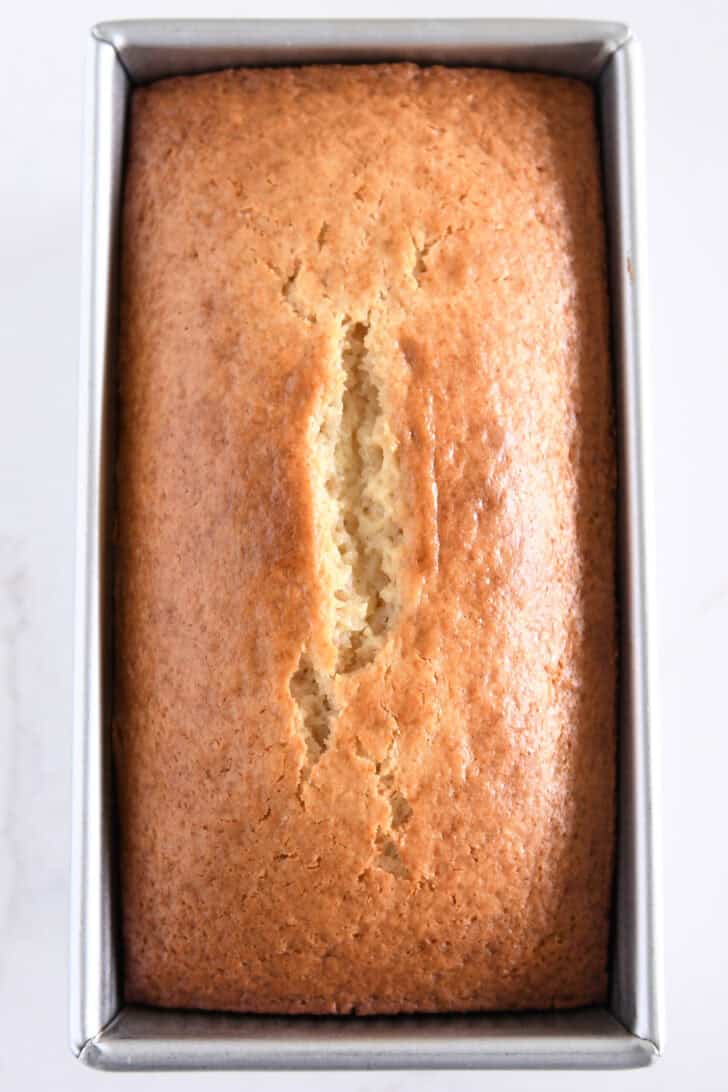 Baked lemon yogurt quick bread in metal loaf pan.