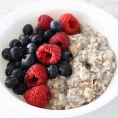 White bowl with chia oats, blueberries, and raspberries.