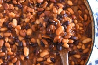 Wooden spoon scooping up calico baked beans.