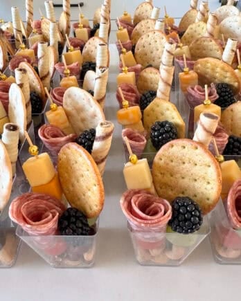 Mini charcuterie cups on white counter.