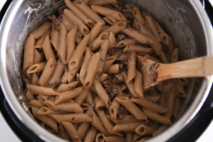 Cooked, creamy pasta in Instant Pot with sun-dried tomatoes.