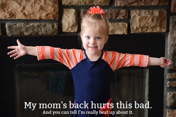 A little girl holding her arms out wide and smiling.