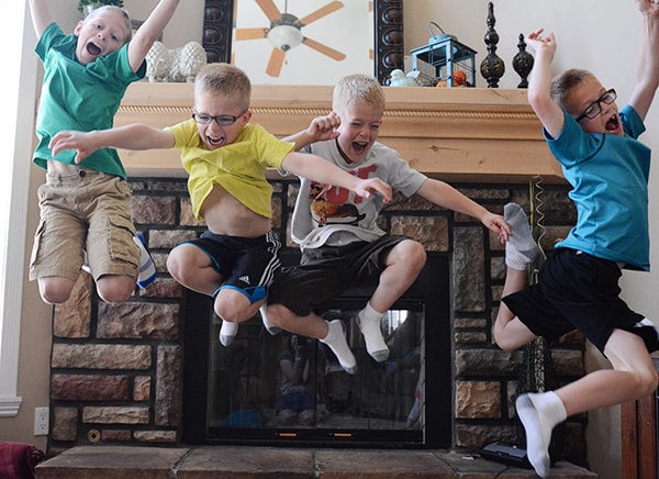 Four little boys jumping in the air. 