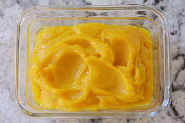 A glass tupperware of pureed pumpkin.
