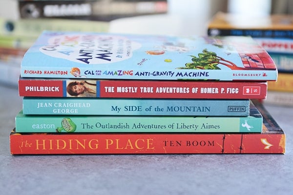 A stack of five books on a kitchen counter.