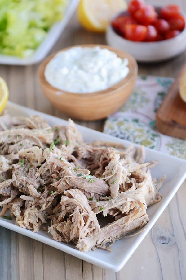 A white tray of shredded Greek pork. 
