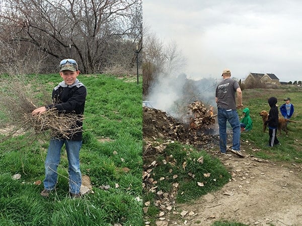 A family outside burning a pile of yard debris. 