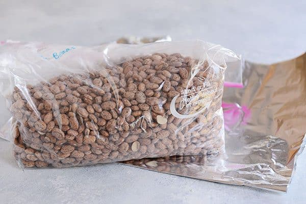 A Ziploc bag of dry pinto beans on a sheet of tinfoil.