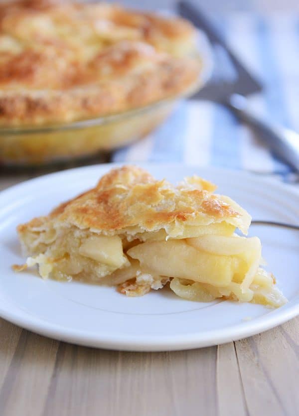 A slice of apple pie on a white plate.