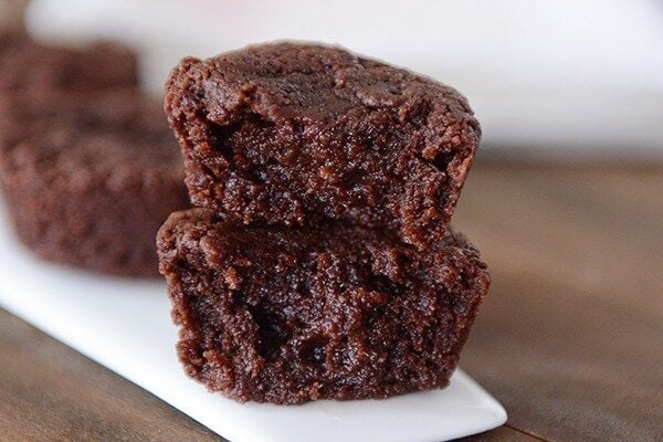 Two brownie bites with bites taken out stacked on top of each other.