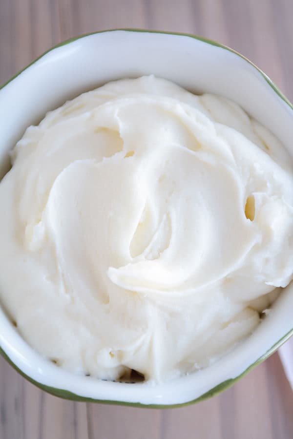 Top view of a large bowl full of vanilla buttercream frosting.