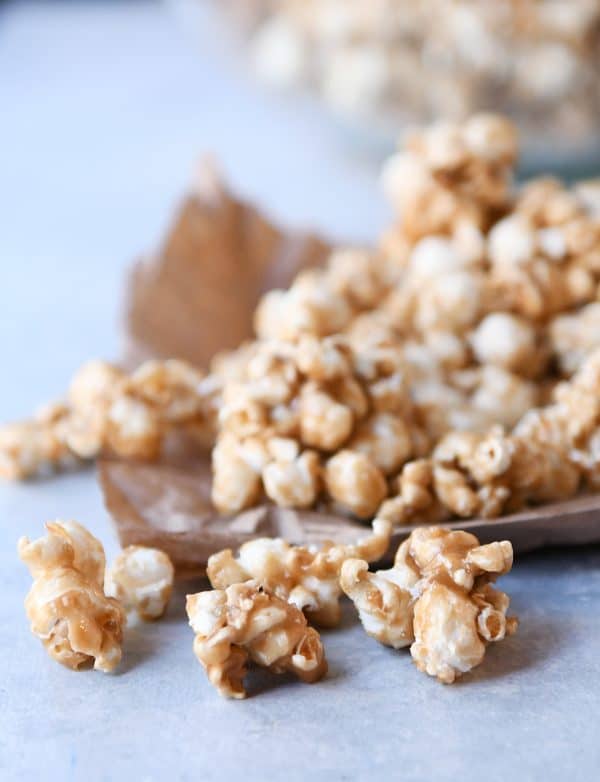 Soft and chewy caramel popcorn on brown paper bag.