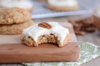 Frosted carrot cake cookie with a bite taken out.