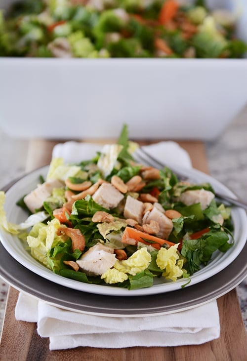 A white plate of cashew chicken salad. 