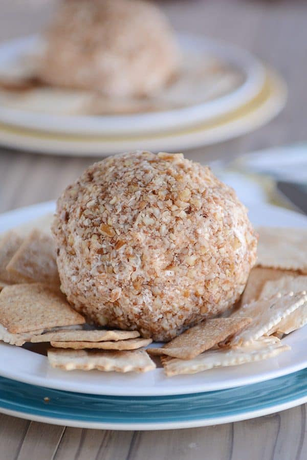 Pecan crusted cheeseball surrounded by crackers.
