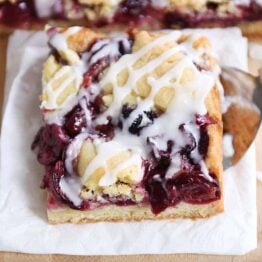 Cherry pie cookie bar on white napkin.