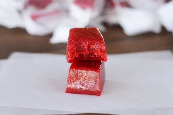 Two cinnamon caramels stacked on top of each other. The top one has a bite taken out.