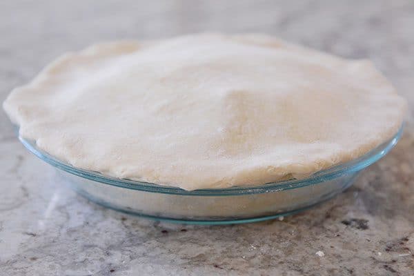 An uncooked pie in a glass dish.