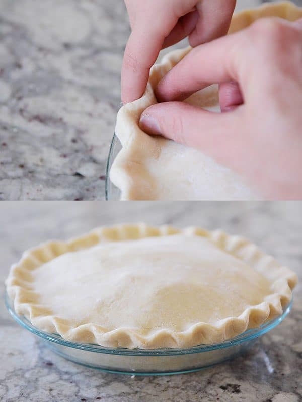 An uncooked apple pie with a crimped crust.