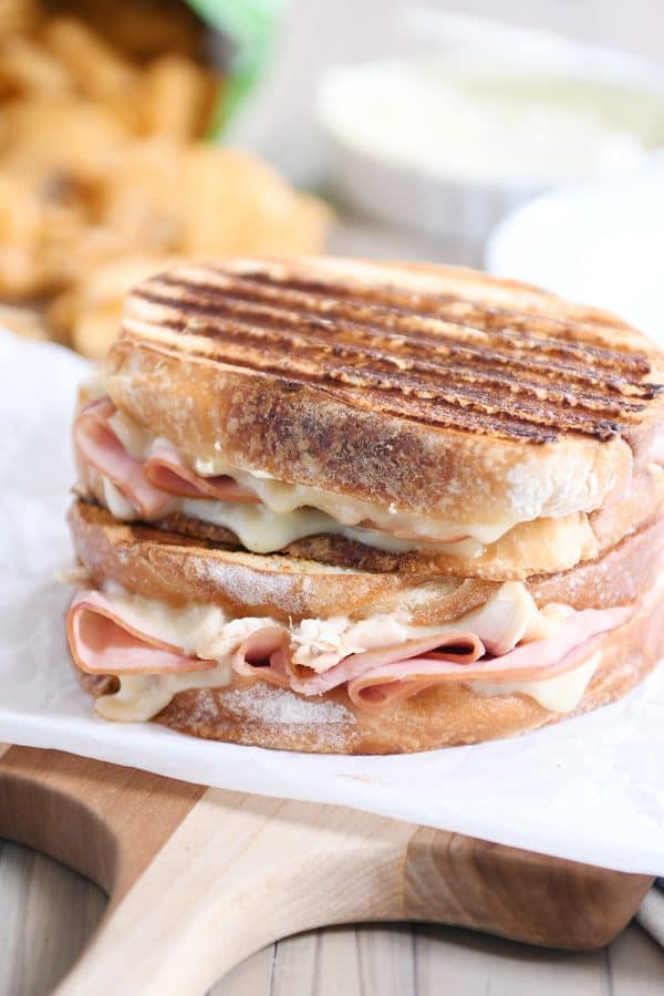 Two chicken cordon bleu panini sandwiches stacked on top of each other.