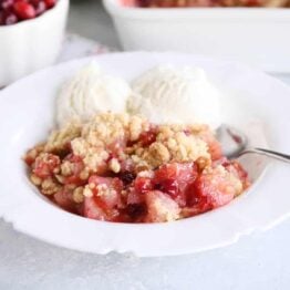 Bowl of cranberry pear crumble with vanilla ice cream.
