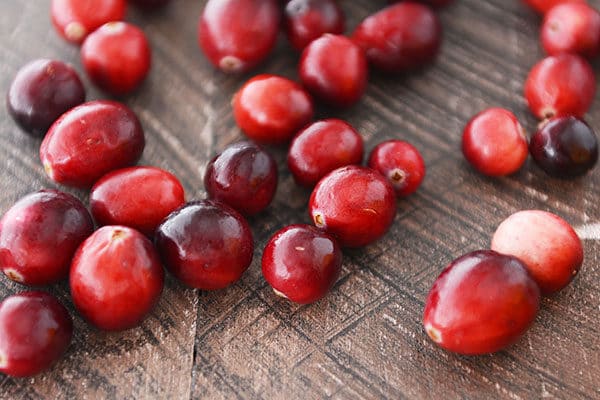 Fresh cranberries sprinkled on a countertop.