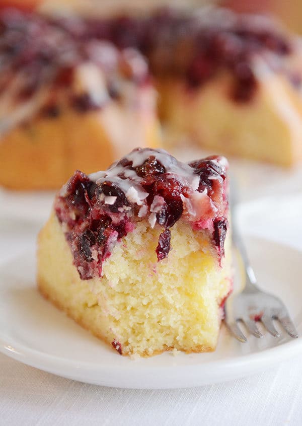 A slice of cranberry lemon bundt cake with a bite taken out.