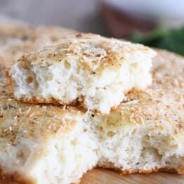 Easy focaccia bread with piece on top of loaf.