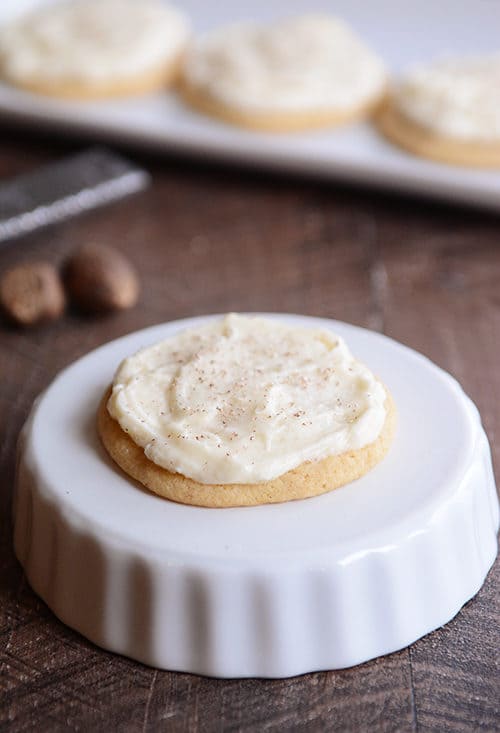 A frosted sugar cookie on an upside down ramekin.