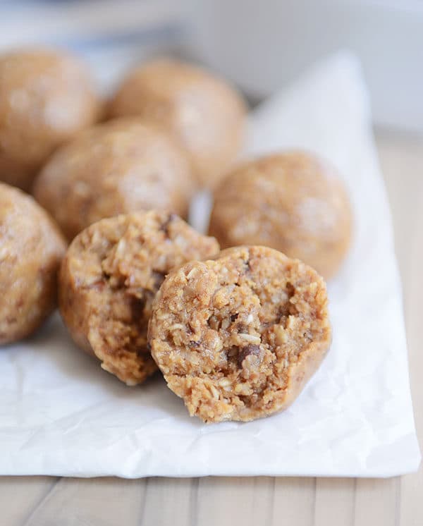 A parchment sheet with protein balls on top. The front two balls have bites taken out of them.