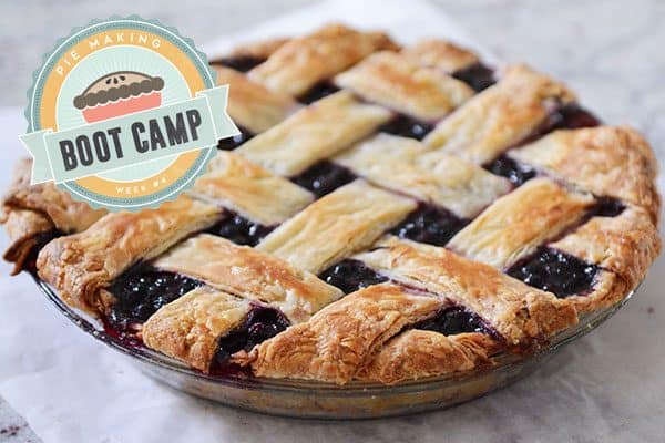 A baked blueberry pie in a glass pie dish. 