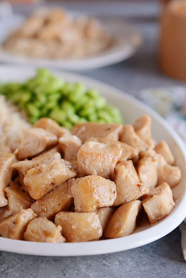 A plate of glazed cooked chicken cubes. 