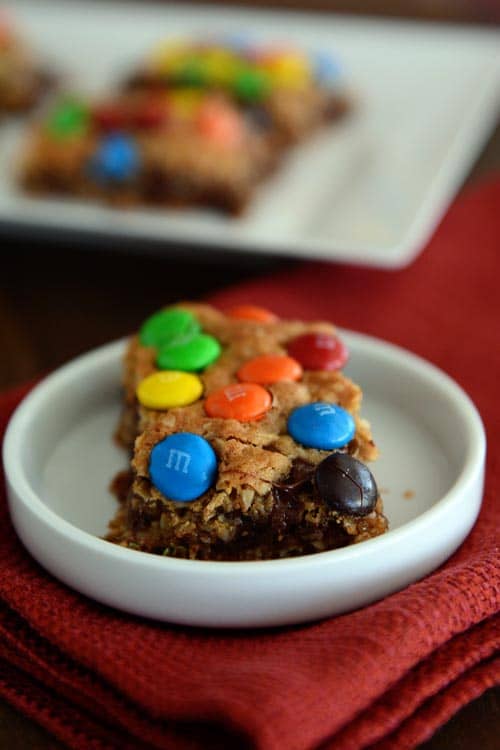 A small white ramekin with an M&M topped oat bar inside.