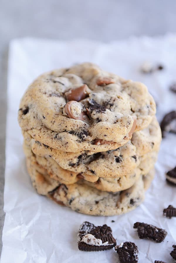 Four chocolate chip Oreo cookies stacked on top of each other on a piece of parchment.