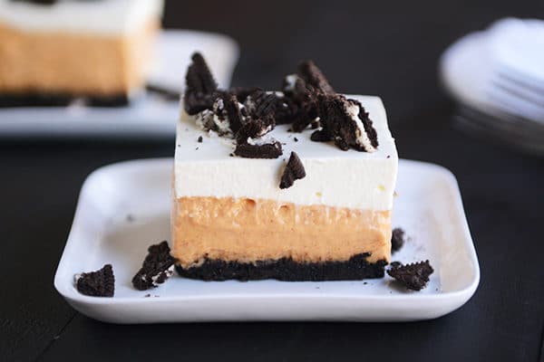 An Oreo crust pumpkin cheesecake bar on a small white plate.
