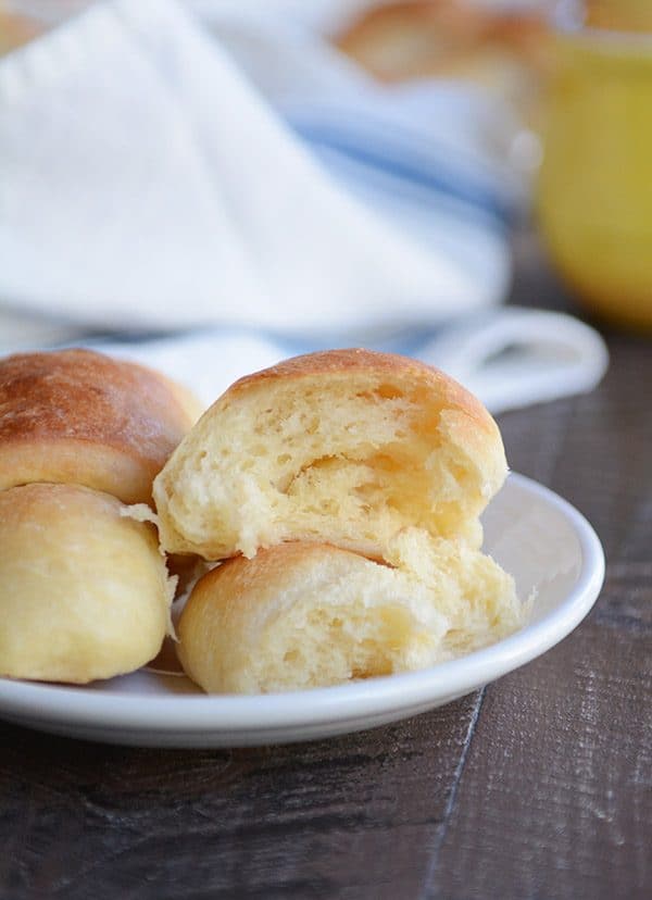 A crescent roll split in half on a white plate.